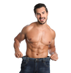 Young man with slim body in old big size jeans on white background