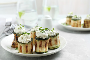 Stuffed zucchini rolls on grey marble table. Space for text