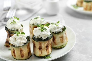 Stuffed zucchini rolls on grey marble table, closeup