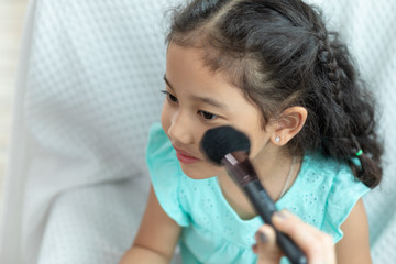 asian baby girl sitting make-up on the white sofa in the room