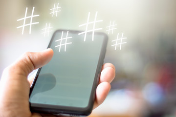 Man hand is playing Social Media idea a word or phrase preceded by a hash or pound sign (#) and used to identify messages on a specific topic with copy space. Soft focus