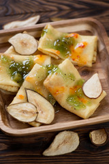 Closeup of crepes topped with fruit jam and pear fruit chips, selective focus, studio shot
