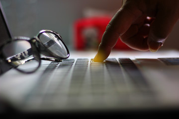 the worker pointing finger on button of laptop.worker is push button delete his job or push button enter tosave his work.