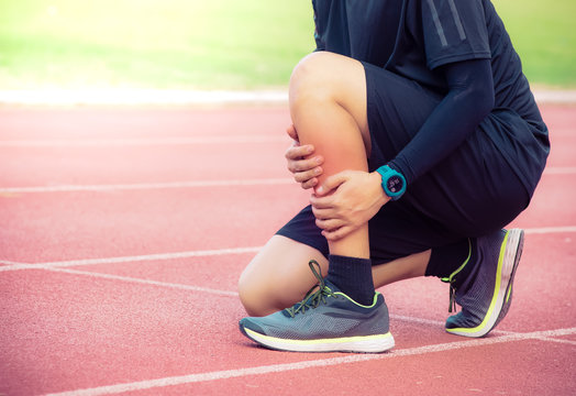 Male runner shin bone injury and pain on running track,Injury from workout concept