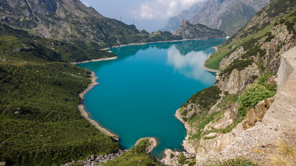 Fototapeta na wymiar Landscape of the Lake Barbellino an alpine artificial lake. Turquoise water. Italian Alps. Italy. Orobie. Lake from which the Serio river is born. Summer time