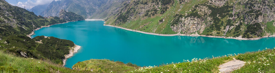 Naklejka na ściany i meble Landscape of the Lake Barbellino an alpine artificial lake. Turquoise water. Italian Alps. Italy. Orobie. Lake from which the Serio river is born. Summer time