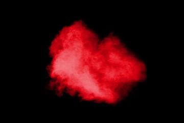 Red color powder explosion on black background.Freeze motion of red dust particles splashing.