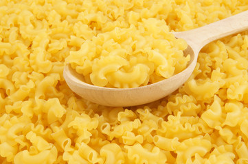 Macaroni background with wooden spoon