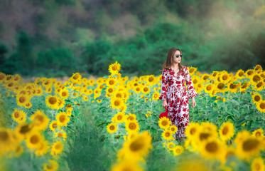  Young beautiful woman stands with a field of sunflowers at Lopburi,Thailand.
