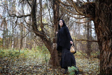 A woman in a witch suit in a forest