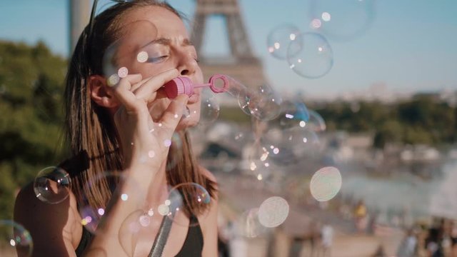 Beautiful girls blows soap bubbles in Paris