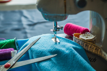  Sewing machine at work, scribble fabric on the background of a meter, scissors and threads