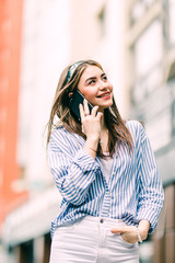 Young woman talking on mobile phone in the street