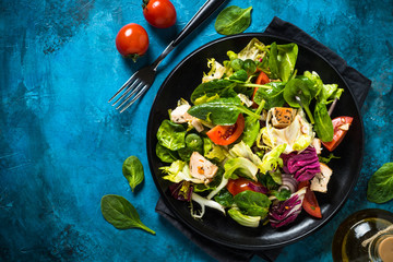 Green salad with chicken and vegetables top view.