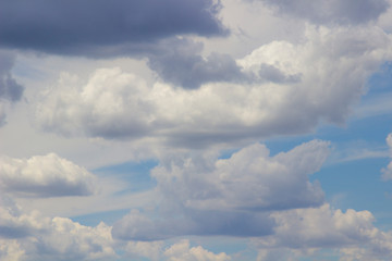 Rain cumulus clouds against blue sky.
