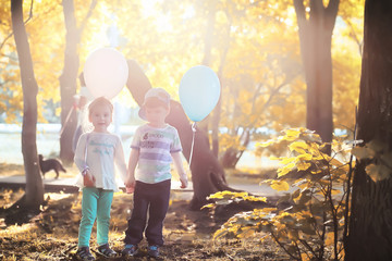 Little children are walking in autumn park