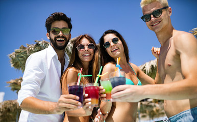 Group of happy friends having fun dancing at swimming pool outdoors