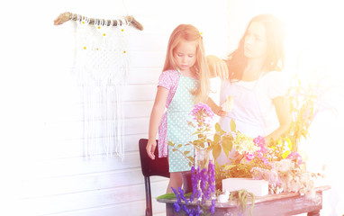 A young girl with a daughter is picking up a bouquet. A young mother with her daughter makes a...