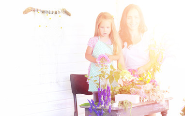 A young girl with a daughter is picking up a bouquet. A young mother with her daughter makes a...