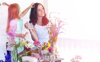 A young girl with a daughter is picking up a bouquet. A young mother with her daughter makes a...