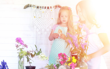 A young girl with a daughter is picking up a bouquet. A young mother with her daughter makes a...