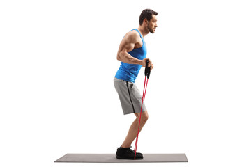Man on an exercise mat with a resistance band