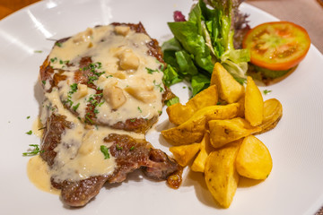 Savory beef steak with creamy mushroom sauce and vegetables