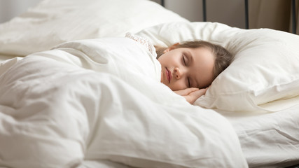 Sweet little kid girl having healthy day nap in bed - obrazy, fototapety, plakaty