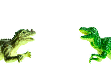 two toy dinosaurs fall into the frame from different sides