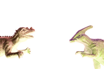 two toy dinosaurs fall into the frame from different sides