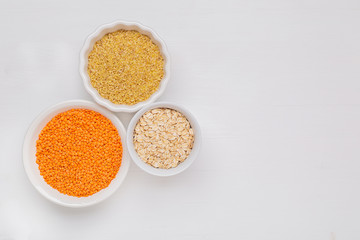 Superfoods and cereals selection in bowls: red lintils,oat flakes and bulgur