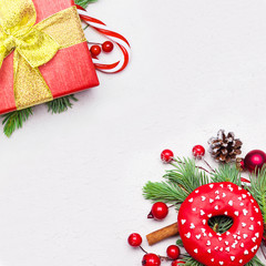Christmas corner composition with green Xmas fir branch, red holly berries and baubles on white...