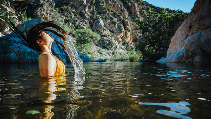 Female model splashing hair in water at deep creek hot springs