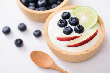 Yoghurt eating with blueberry, apple and lime on white background, healthy food