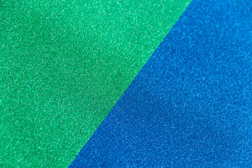 Fototapeta premium Green and blue sparkling background from small sequins, closeup. Brilliant shiny backdrop from textile.
