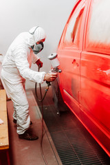 Details of industrial worker, mechanic engineer painter painting a car using a car sprayer, airbrush compressor