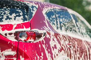 Car wash with soap. Manual car wash with pressurized water in car wash outside.Summe Washing. Cleaning Car Using High Pressure Water. Washing  with soap. Close up concept. 