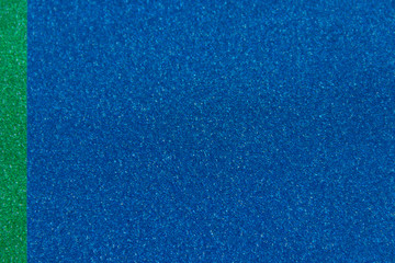 Green and blue sparkling background from small sequins, closeup. Brilliant shiny backdrop from textile.