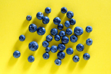 Blueberry berry on a yellow background. Summer and vitamins
