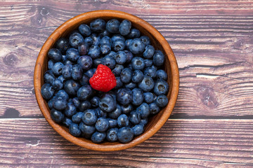 Red raspberries and blueberries in a wooden bowl. Berries, summer and vitamins