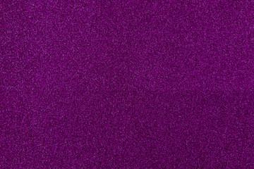 purple sparkling background from small sequins, closeup. Brilliant shiny backdrop from textile.