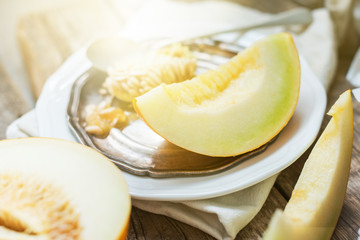 fresh yellow melon only cut on plate wooden table