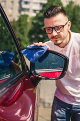 Car detailing - the man holds the microfiber in hand and polishes the car. Selective focus. Car...