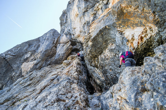 Two women on the via ferrata route at Prisojnik (Prisank) in the Julian Alps, Triglav National Park, Slovenia. Mountaineering on a vertical rock section.