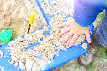Baby hygiene and hand washing idea. Child hand plays in the sandbox close up.