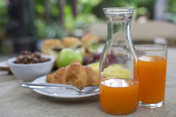 Breakfast including, bread,milk,honey, orange juice, muesli and fruits