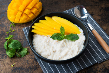 Oatmeal with tropical fruits, mango. Healthy Breakfast bowl.