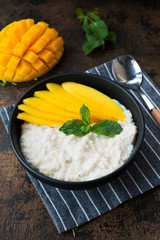 Oatmeal with tropical fruits, mango. Healthy Breakfast bowl.