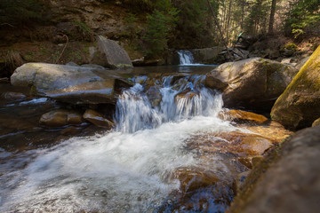 Fototapeta na wymiar Small waterfall on a mountain river in Spring