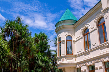 View of Botanical garden in Batumi, Georgia: administration building facade and palms over blue sky